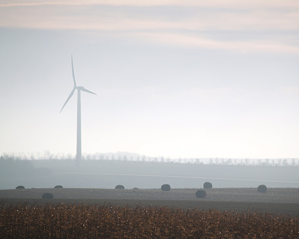 large wind turbines obscured by a hazy day in minnesota