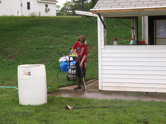 nine year old power washing cement after flood receded 