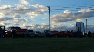 cars parked around football field for high school game
